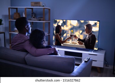 Affectionate Young Family Watching TV At Home