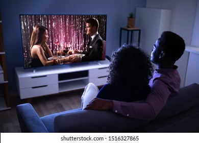 Affectionate Young Family Watching TV At Home