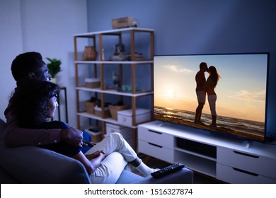 Affectionate Young Family Watching TV At Home