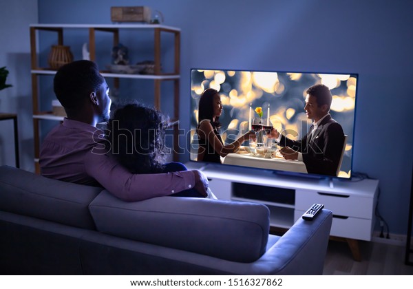 Affectionate Young\
Family Watching TV At\
Home
