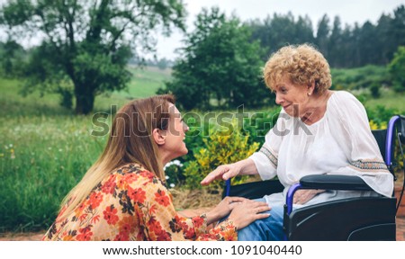 Similar – Young woman talking to elderly woman in wheelchair