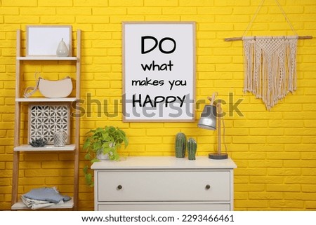 Affirmation. Poster with phrase Do What Makes You Happy on yellow brick wall in room