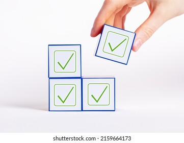 Affirmative unanimous decisions making. Hand holding cube with check mark. Voting, unity in thoughts, conformism, approval concept. High quality photo - Shutterstock ID 2159664173