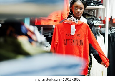 Afican american women in tracksuits shopping at sportswear mall against shelves with sweatshirt. Sport store theme. - Powered by Shutterstock