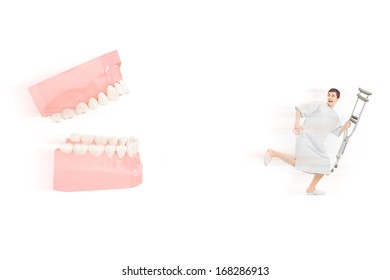 Afraid Male Patient In Hospital Gown With Crutch Running Away From Open Dentures, Isolated On White Background