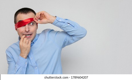 Afraid Man Removes Blindfold, Portrait, White Background, Copy Space, 16:9