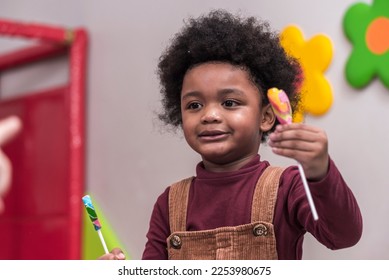 Africa American boy hold on colourful candy in Kids birthday celebratiion party. - Shutterstock ID 2253980675