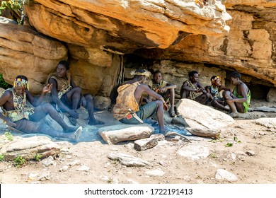 AFRICA, TANZANIA, MAY, 10, 2016 - Hadzabe tribe mens shelter from the hot sun in the shadow of a rock. Hadzabe tribe threatened by extinction in Tanzania, Africa