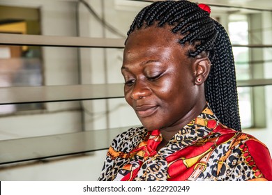 Africa Woman Sitting At A Bus Station Waiting For Her Bus. Location Accra Ghana West Africa