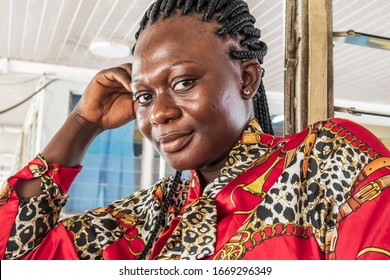 Africa Woman Sitting At A Bus Station Waiting For Her Bus. Location Accra Ghana West Africa