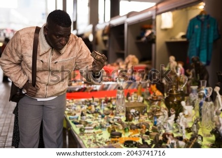 AfricaAmerican man chooses antiques on the flea market