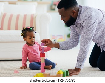 africam american family, father and daughter playing with colorful wooden blocks at home