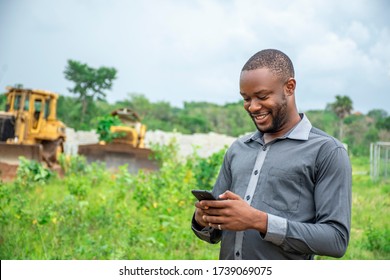 African Agricultural Businessman, Using A Mobile Phone On A Plot Of Land