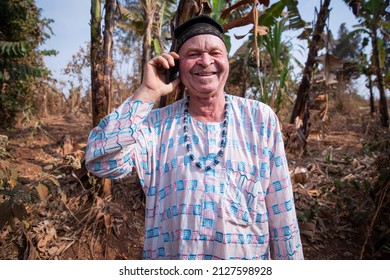 African albino senior makes a phone call and is happy. Man with albinism syndrome dressed in traditional African clothes. - Powered by Shutterstock