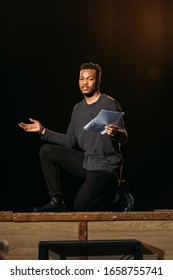 African American Actor Holding Scenario On Stage During Rehearse