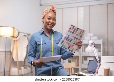 African american adult female woman fashion designer cloth tailor creative working for new collection.Happy online store owner preparing an order for shipping . - Shutterstock ID 2258023397