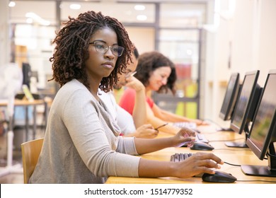 African American Adult Student Working In Computer Class. Line Of Man And Women In Casual Sitting At Table, Using Desktops, Typing. Staff Training Concept