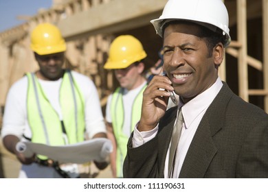 African American architect phoning at a construction site