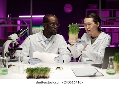 African american and asian scientists attentively looking at sample of herb analyzing its growth - Powered by Shutterstock