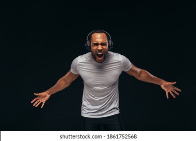 African American Athlete Shouting During Workout. Fit Man Expressing Emotions While Listening To Music On Headphones.