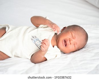 African American Baby Boy Crying On A White Bed.