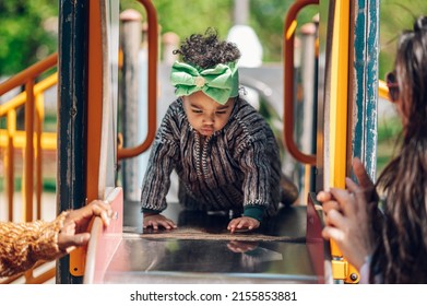 African American Baby Girl Playing On An Outdoor Playground. Kid Playing On School Or Kindergarten Yard. Activity And Play Center For Young Child.