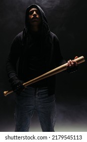 African American Bandit In Hood Holding Baseball Bat On Black Background With Smoke