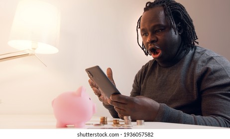 African American Black Man Checking Bank Balance Using Mobile App. Investing And Wealth Growth Concept. High Quality Photo