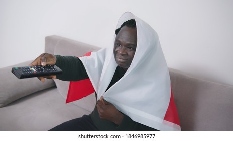 African American Black Man Holding Polish Flag And Watching Sport Game On Tv. High Quality Photo