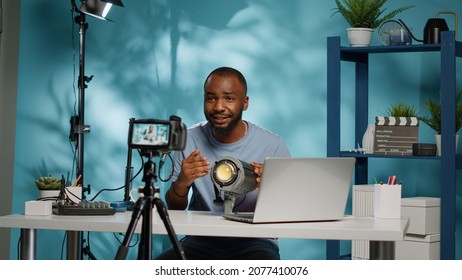 African American Blogger Reviewing Studio Light On Camera For Vlog Channel. Black Influencer Doing Recommendation And Review Product Used For Videography Equipment On Video Podcast.