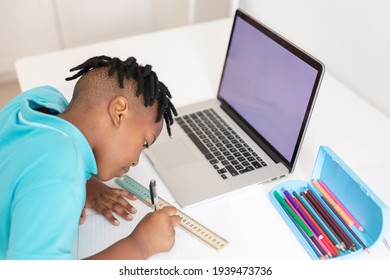 African American Boy At Desk Using Laptop With Copy Space For Online School Lesson. Staying At Home In Isolation During Quarantine Lockdown.