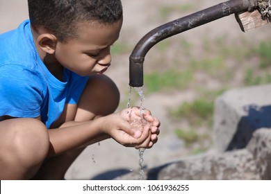 African American Boy Drinking Water From Tap, Outdoors