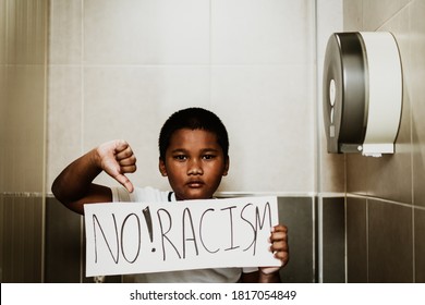 African American Boy Holding Board No Racism In Toilet.No Bully At School.Black Boy Kid.Bullying, Discrimination And Racism.Black Lives Matter Activist Movement Protesting Against Racism And Fighting.