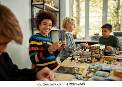 African American Boy Looking At Camera With A Smile While Making Toys At A Technology Class. Smart Kids And STEM Education. Science And People Concept. Horizontal Shot