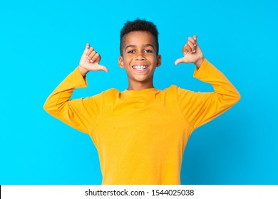 African American boy over isolated blue background proud and self-satisfied