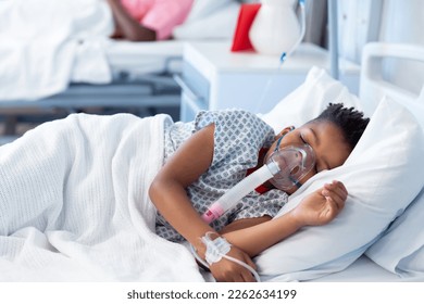 African american boy patient on ventilator asleep in hospital bed with copy space. Hospital, medical and healthcare services. - Powered by Shutterstock