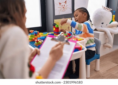 African american boy playing with construction blocks having psychotherapy at kindergarten - Powered by Shutterstock