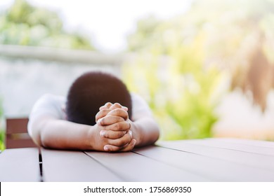 African american boy praying at home.coronavirus Covid-19.Stay at home praying to GOD.Online church worship in sunday.black boy child hand praying at home.Social distancing.No racism.Pray for america.