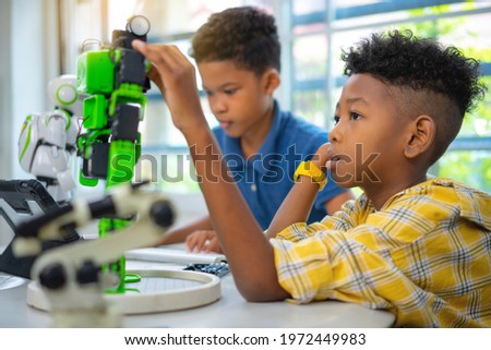 African american boy are setting robot kit in classroom.