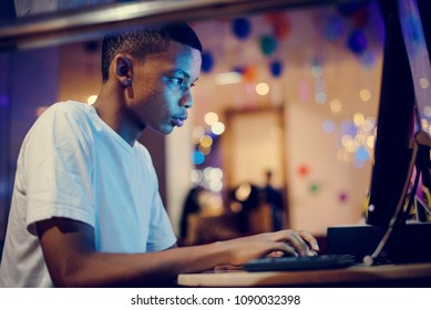 African American Boy Using A Computer At Night