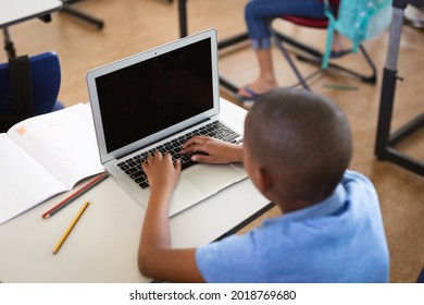 African american boy using laptop while sitting on his desk in the class at elementary school. school and education concept - Shutterstock ID 2018769680