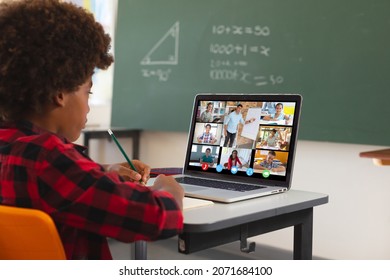 African American Boy Using Laptop For Video Call, With Diverse High School Pupils On Screen. Communication Technology And Online Education, Digital Composite Image.