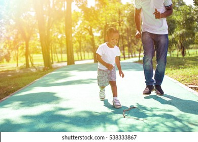 African American Boy Walking And Playing With Dad In Green Park Outdoor