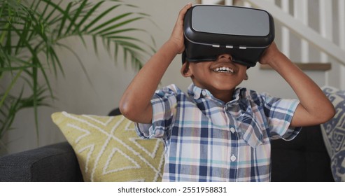 African american boy wearing vr headset and having fun. childhood, leisure and discovery using technology at home. - Powered by Shutterstock