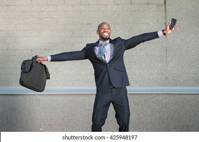 African American Business Man Is Happy Standing On A Gray Background Urban Wall