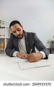 African American Business Man Signs Documents In His Office. Latino Male Prepares Before Business Meeting. Taking Notes.