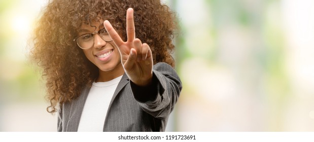 African American Business Woman Wearing Glasses Smiling Looking To The Camera Showing Fingers Doing Victory Sign. Number Two.