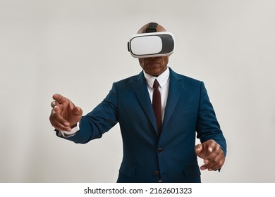 African american businessman or ceo manager using Virtual reality glasses. Bald adult man wearing suit. Modern entertainment and leisure. Isolated on white background. Studio shoot. Copy space - Powered by Shutterstock