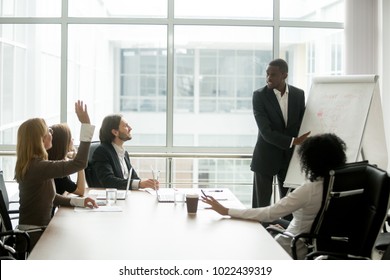 African american businessman giving presentation discussing project with multi-ethnic group at corporate training, black teaching coach answering questions asked by audience during business seminar