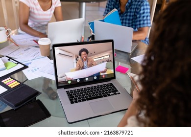 African American Businessman Holding Blueprint During Video Call With Biracial Female Colleague. Unaltered, Business, Wireless Technology, Planning, Working, Teamwork And Office Concept.